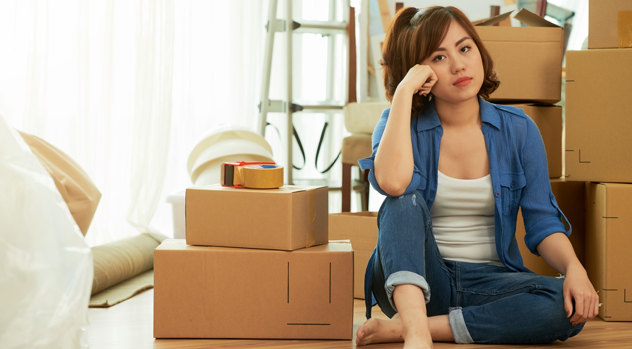 full-shot-tired-woman-sitting-floor-packing-boxes